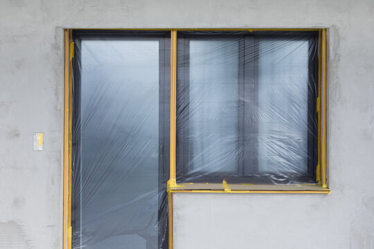 Protective plastic sheeting covering window and balcony door