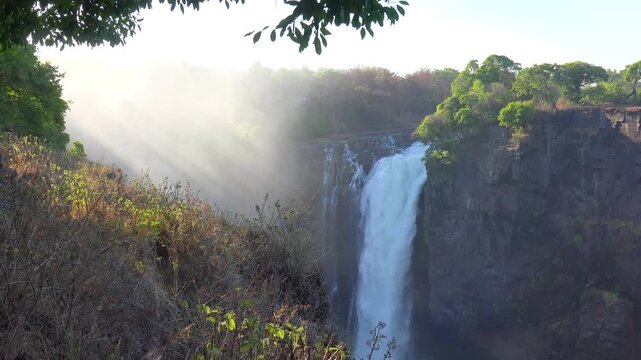 Mosi oa tunya falls in victoria falls zimbabwe during morning sunlight with mist.