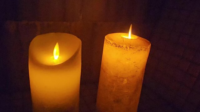Candle flames dance in light during a quiet moment in a cozy room