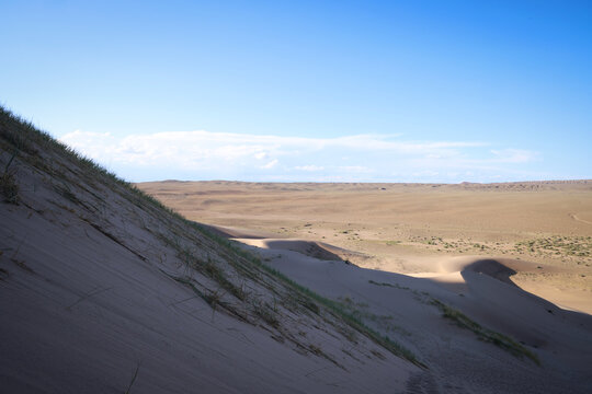 Dune di sabbia nel deserto della Mongolia sotto il cielo azzurro