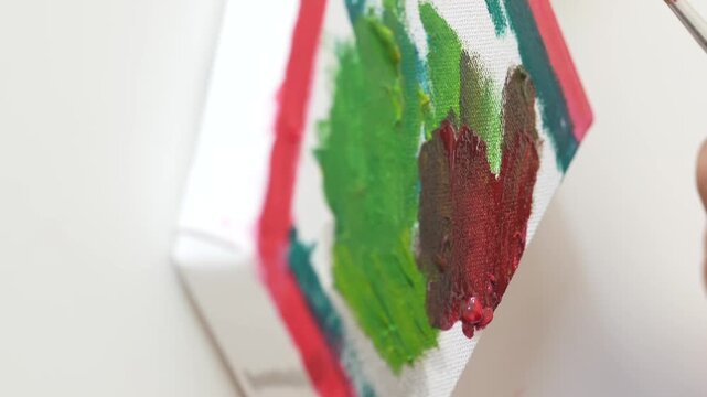 Close up hands of artist drawing on canvas with paint brush, creating artwork using vibrant colors, showcasing creative hobby and artistic expression