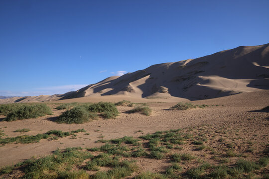 Dune di sabbia nel deserto della Mongolia sotto il cielo azzurro