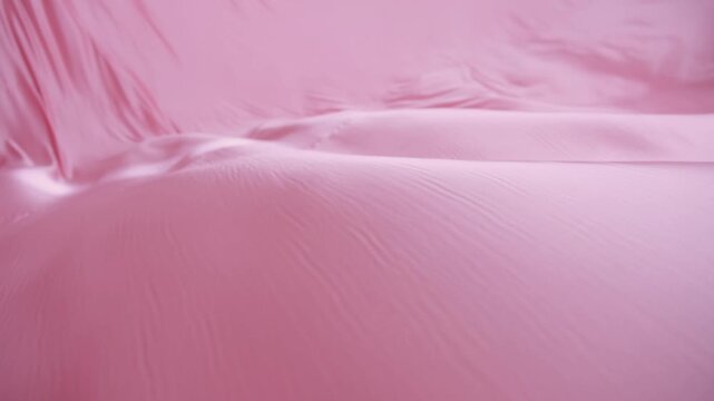 A pink sheet of fabric with a wave pattern