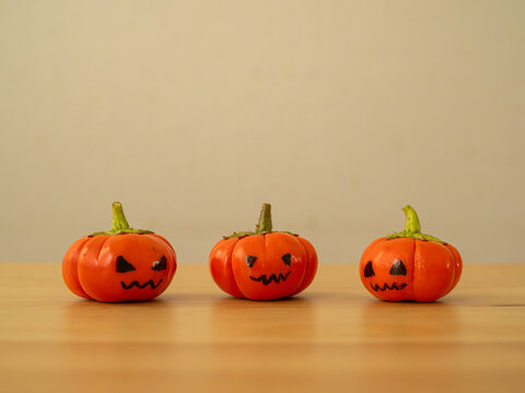 ジャックオーランタンの顔を手書きでソラナム・パンプキンに描いたハロウィンの飾り｜コピースペース