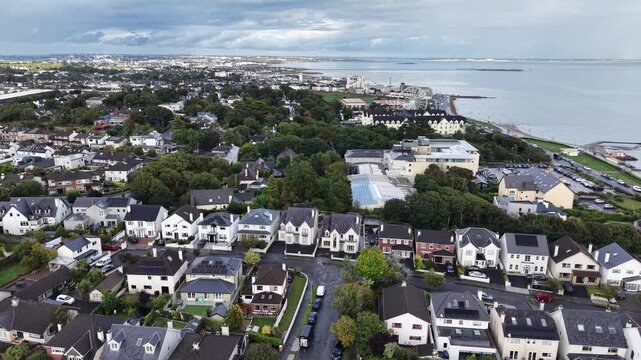 Aerial drone footage overlooking Salthill in Galway, Ireland, with residential neighborhoods, the Salthill Promenade, Galway Bay and the surrounding coastal landscape. The panoramic view captures