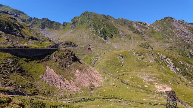Cable car crossing rugged mountain slopes above the Transfagarasan road in the Romanian Carpathians