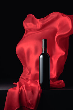 Bottle of red wine and flutters of red cloth.