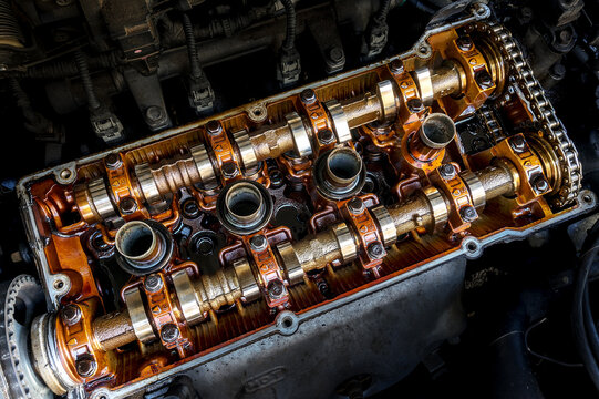 Close up top view of engine parts headers pistons block and chain gear.