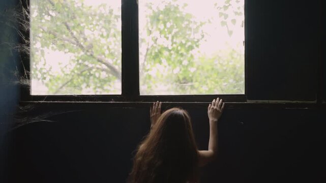 Unhappy Asian woman with sick and experienced dizziness while alone standing looking out through a window and emotional stress then fainted lost consciousness collapsed on floor in old room at home. 
