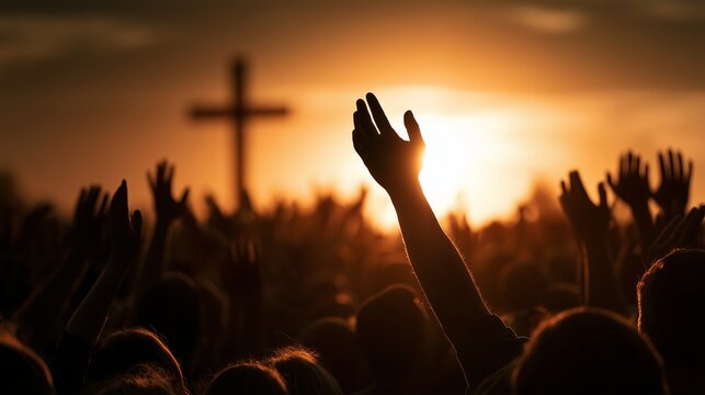 Crowd gathers for worship service at sunset with hands raised under cloudy sky