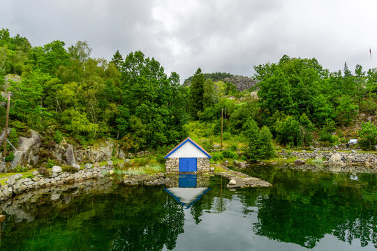 Naust boathouse reflecting in tranquil Norwegian fjord water