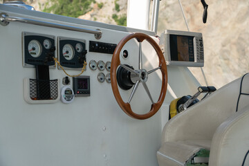 Helm station of a catamaran with steering wheel, captain seat and control panel. Marine navigation equipment, vessel operation, boating, sea travel, sailing and nautical transport. © Sofia