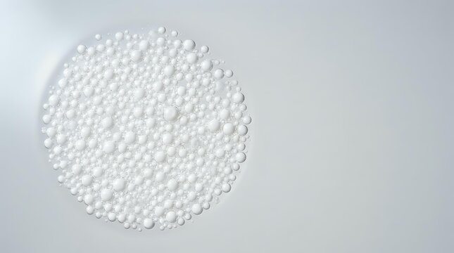 White polystyrene foam beads or pellets arranged in circular form on neutral background for packaging, insulation, and cushioning material applications