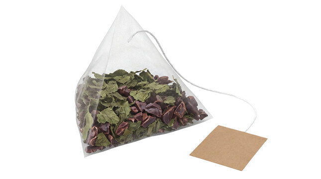 Pyramid tea bag with loose herbal leaves, mesh silk sachet with brown paper tag, premium organic tea infuser for brewing isolated PNG with Transparent Background