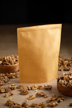 Blank craft paper zipper pouch packaging mockup surrounded by walnut kernels in wooden bowls on stone table
