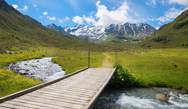 wooden footbridge over Dischmabach creek, Durrboden. landscape near Davos, switzerland