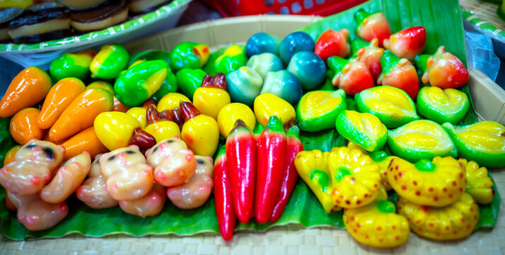 Traditional Vietnamese mung bean fruit-shaped cakes, made from rice flour, sugar, and ground mung beans, steamed in molds to create colorful fruit and vegetable shapes.