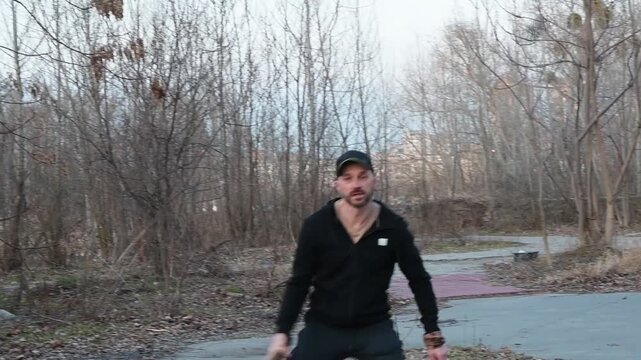 Athletic Man Playing Tennis with Wooden Rackets Outdoors in Autumn Park