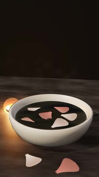 Rose petals floating in a white ceramic bowl of dark water with candlelight and rising steam on slate, vertical spa video background, seamless loop