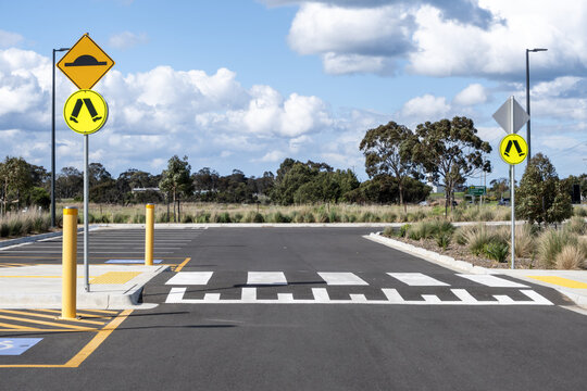 A&nbsp;raised pedestrian zebra crossing within a public car park facility, featuring road signage for speed humps and pedestrian safety, bollards, tactile paving, and clear road markings&nbsp;in Australia