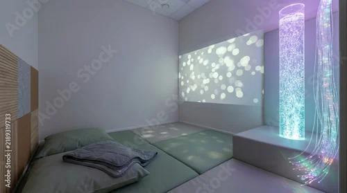 Empty sensory room in clinic with calming light projections and bubble tube for neurodivergent children
