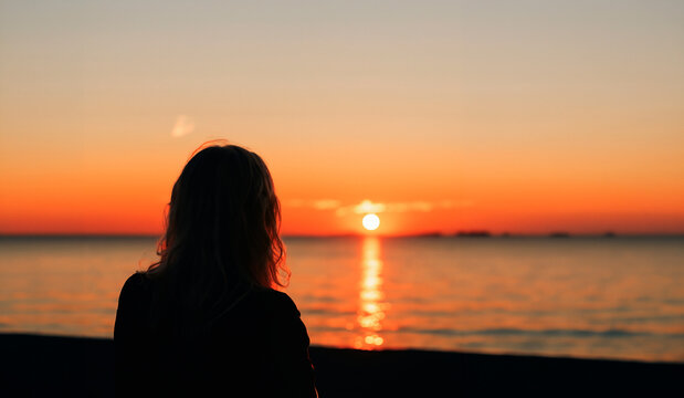 a woman watching a sunset on a torpical beach generated with artificial intelligence