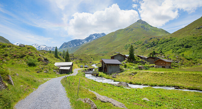 Idyllic hike in the Dischma Valley near Davos. Am Rhin settlement with farmhouses, grisons.