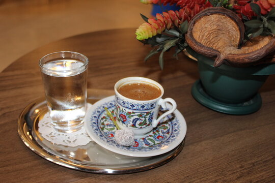 Turkish espresso in a small cup with a glass of water.