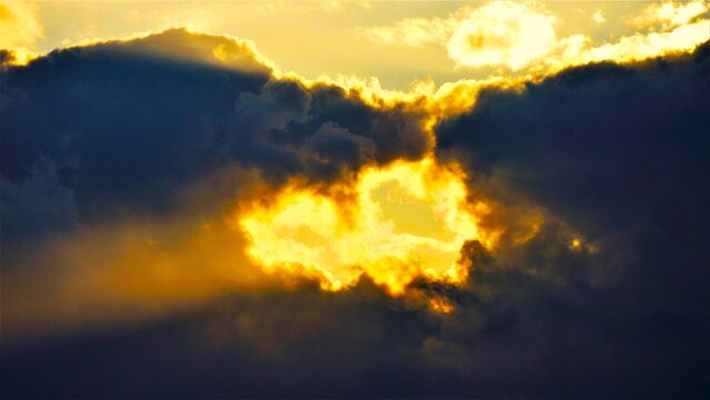 Sunset sky with dramatic clouds with rays of light shines bright, heavenly scene, clouds and light background