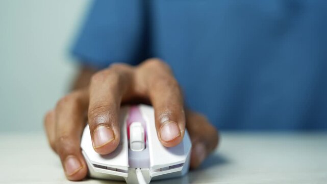 Hand using a computer mouse at desk, Close-up of a person using a white computer mouse on a desk, showing online work, technology, and digital communication.