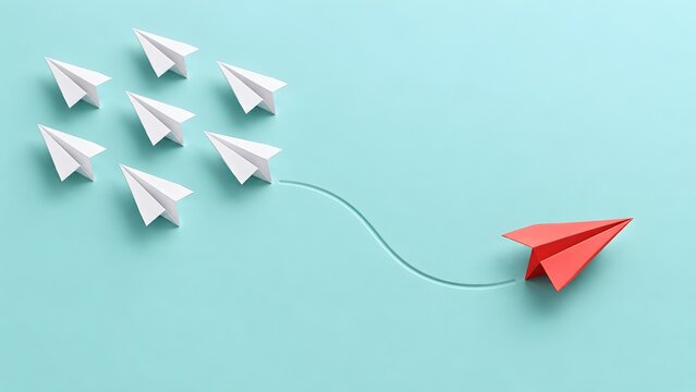 Concept of changing direction and leadership featuring a red paper airplane breaking away from a group of white airplanes on a blue background.
