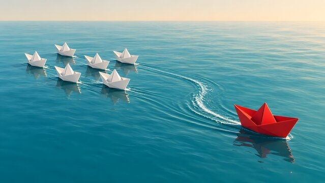 Business leadership and navigation concept showing a red paper boat leading the way and breaking from a fleet of white boats on the ocean.