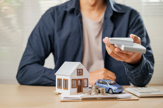 A man with cash, house, and car models symbolizes saving and managing finances. Includes loan strategies, tax benefits, and property investments