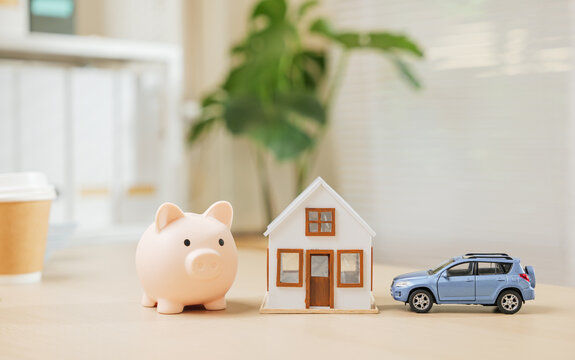 Piggy bank with house and blue car models symbolizes saving money for a dream home and auto. Highlights property investment, asset building, and expense management with finance