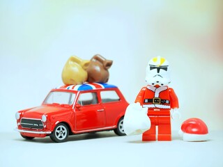 Fototapeta premium Indonesia - September 11, 2023 : Mini toy at table with blurred background. Santa Claus carrying gift concept design.