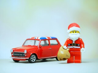 Fototapeta premium Indonesia - September 11, 2023 : Mini toy at table with blurred background. Oldman Santa Claus carrying gift concept design.