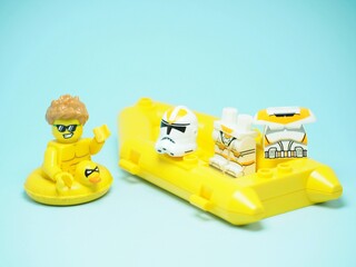 Fototapeta premium Indonesia - September 13, 2023 : Mini toy at table with blurred background. Holiday concept design. Stormtrooper take off the shield clothes or shirt and swimming in the water.