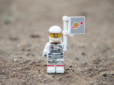 Indonesia - April 14, 2025 : Mini toy of action figure at table with blurred background. Miniature photography concept design. Minifigure of astronaut character at outer space.