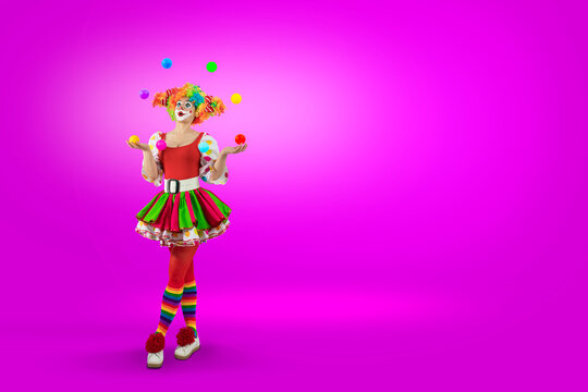 Funny juggler female clown juggling balls in the circus, woman entertainer as Joker in suit and wig, with clown whiteface makeup. Trickster, jester, pantomime, mime,  professional actor at events