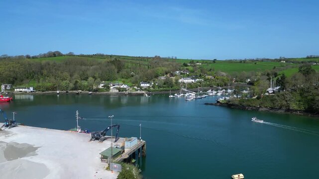 Fowey, Cornwall, England: DRONE VIEWS: Fowey Harbour on the River Fowey; a dock loader prepares a heap of china clay. Fowey docks is a crucial hub for the local mining industry to export clay abroad.