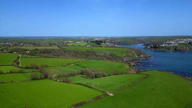 River Fowey, Cornwall, England: DRONE VIEWS: The drone flies over the South West Coast Path near the River Fowey estuary; to the right of picture is the riverside village of Polruan.