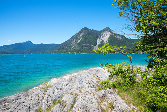 rocky shore of lake Walchensee, surfers destination with view to Herzogstand mountain
