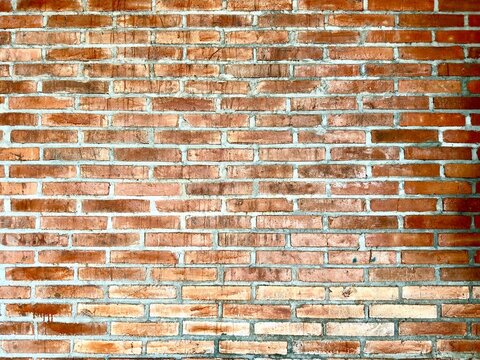 Rough orange brick wall background texture, exposed masonry surface with rustic pattern