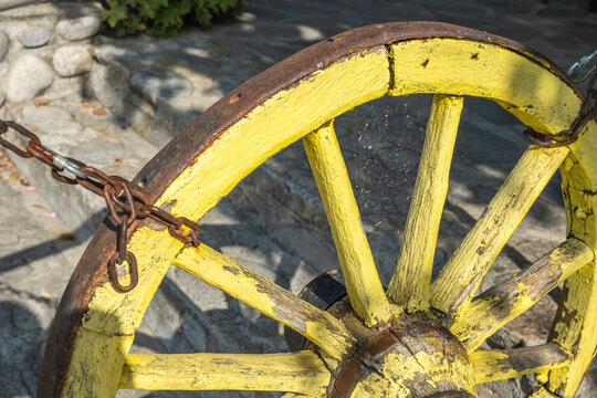 Vintage wooden cartwheel. Village background.