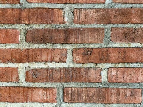 Close up rough orange brick wall texture, zoomed exposed masonry surface with rustic pattern