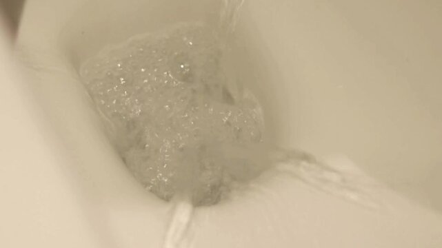 A close up of a toilet flushing white toilet bowl