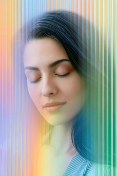 Portrait of a young woman with closed eyes, featuring a colorful abstract overlay of vertical lines in pastel shades, creating a dreamy and ethereal effect