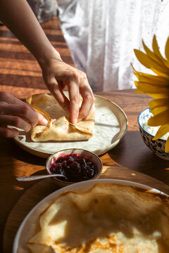 Homemade crepes with cottage cheese and berry jam served for breakfast