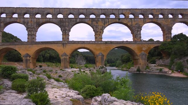 Ancient roman pont du gard bridge spanning gardon river in france with beautiful scenic landscape and historical architecture.