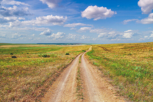 Endless dirt road in the steppe in summer